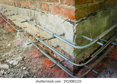 Reinforcement Of Base Of Old House For Wall Insulation With Foam Plastic. Reinforcement Is Connected To Each Other With Wire For Reinforcement And Is Fixed With Metal Pins At Base Of Foundation.