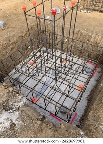 Reinforcement of an isolated footing in a construction site. Foundation ready to pour concrete, with all the rebars assembled. Grid of rods for a new structure.