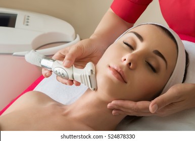 Rejuvenating facial treatment. Model getting lifting therapy massage in a beauty SPA salon. Exfoliation, Rejuvenation And Hydratation. Model and Doctor. Cosmetology.  Close up, selective focus.
