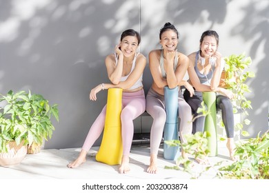 Relationship Asian Generation Woman Diverse Friendship And LGBT Healthy In Group Class Of Exercise Yoga At Gym. Cheerful Sport Girls Group Happy Smile, Use Hand To Chin, Sit On Bench At Shade Outdoor.