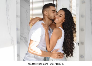 Relationship Concept. Loving Young Arab Man Kissing His Happy Girlfriend In Bathroom, Cheerful Middle Eastern Couple Having Fun While Making Morning Beauty Routine Together At Home, Closeup - Powered by Shutterstock