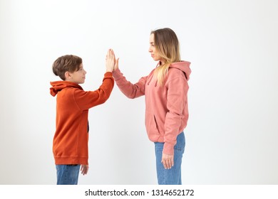 Relationship, Mothers Day, Children And Family Concept - Teen Boy Giving High Five To His Mom On White Background