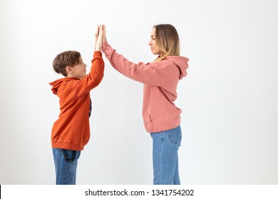 Relationship, Mothers Day, Children And Family Concept - Teen Boy Giving High Five To His Mom On White Background