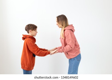 Relationship, Mothers Day, Children And Family Concept - Teen Boy Giving High Five To His Mom On White Background