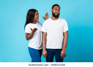 Relationship Problem Concept. Portrait Of African American Couple Arguing, Angry Displeased Black Woman Yelling At Annoyed Boyfriend Who Ignoring Her, Isolated Over Blue Studio Background