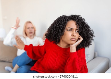Relationship Problems and Conflict Between Two Diverse Female Friends at Home. Sad Woman Ignoring Her Friend During Argument. Friendship Crisis, Misunderstanding and Mental Health Concept.
