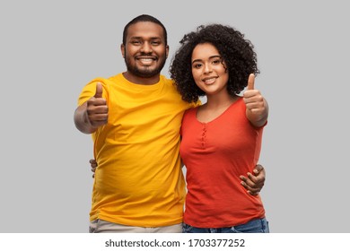 relationships and people concept - happy african american couple showing thumbs up over grey background
