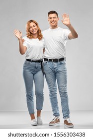 Relationships And People Concept - Happy Couple In White T-shirts Waving Hands Over Grey Background