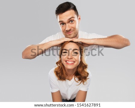 relationships and people concept - portrait of happy couple in white t-shirts over grey background