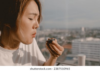 Relax asian woman eating at balcony window good warm vibes weekends lifestyle. - Powered by Shutterstock