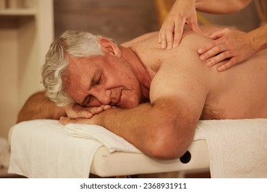 Relax, back massage and senior man at a spa for luxury, self care and muscle healing treatment. Health, wellness and elderly male person on a retirement retreat for body therapy at a natural salon. - Powered by Shutterstock