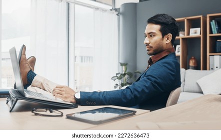 Relax business man with his feet up on desk working on laptop for job confidence, productivity and successful career. Serious Asian CEO, boss or professional person relaxing in office on computer