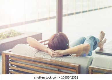 Relax business woman lifestyle at home sitting on modern chair in living room looking out of window toward beautiful cityscape downtown urban landscape city life w/ sunlight effect: