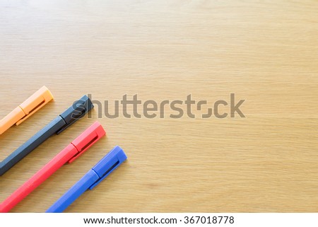 Relax color ball pen on the wood table, with free text space on the right for designer.