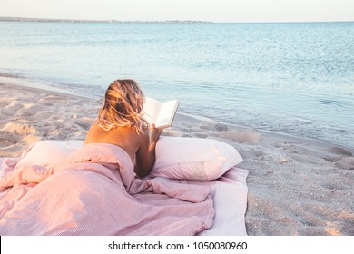 Relax Concept. Cozy And Comfortable Bed Near The Sea. Summer Vacations Still Life. Woman Reading A Book.