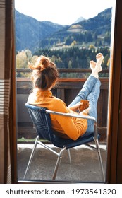 relax. girl sitting in a chair on a balcony with mountain views