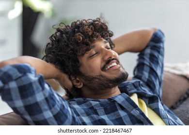 Relax At Home, Positive Thinking Concept. Portrait Of Happy Asian Man Lying On Sofa Resting. Young Male Throwing His Hands Behind His Head Thinks Of Something Good And Smiles