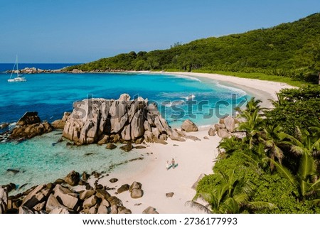 Relax on the pristine sands of Anse Cocos beach, surrounded by crystal clear waters and stunning rock formations. Perfect for sunbathing, swimming, La Digue Seychelles