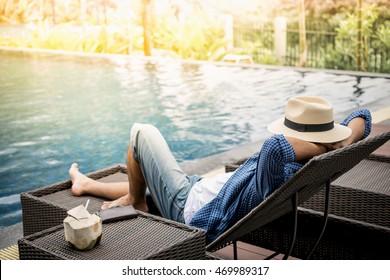 Relax In The Pool. Young And Successful Man Lying On A Sun Lounger At The Hotel On The Background Of Sunset.