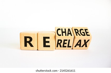 Relax And Recharge Symbol. Businessman Turned Cubes And Changed The Word 'relax' To 'recharge'. Beautiful White Table, White Background. Business, Relax And Recharge Concept. Copy Space.