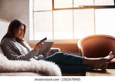 Relax, tablet and credit card with a woman banking online on a sofa in the living room of her home. Ecommerce, financial freedom and shopping with a young female customer or consumer in her house - Shutterstock ID 2302678985