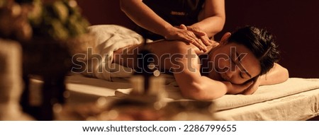 Relaxation Asian woman back massage with masseur in cosmetology spa centre. Relaxing female customer get service aromatherapy massage with masseuse in spa salon.