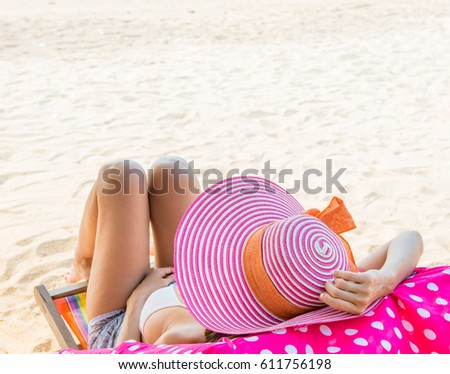 Relaxation Beautiful woman in hat sunbathing on tropical beach, Woman relaxing on the beach
