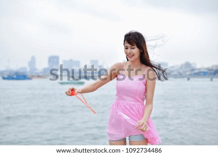 Relaxation concept. Asian girls are playing bubbles with fun. Beautiful girl relaxing on the beach. Beautiful girls like to do activities and play bubbles at the beach.