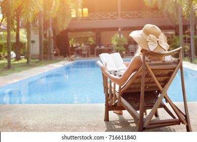 relaxation concept, woman reading book near swimming pool of hotel - Powered by Shutterstock