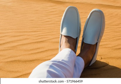 Relaxation. Mans Legs/feet Lying On The Hot Desert Sand.