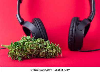 relaxation,chill out when listening to hip-hop music after using marijuana,headphones and cannabis bud on coral background.