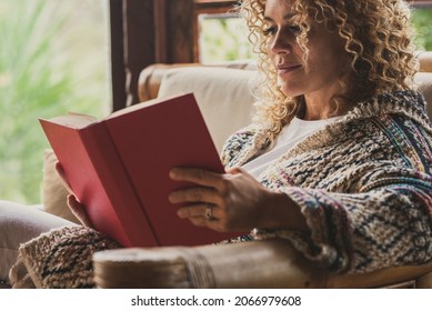 Relaxed Adult Lady Reading A Book Sitting On The Chair At Home With Outside View. Concept Of Female People Happy Lifestyle Living Alone. Attracvite Woman Studying Indoor