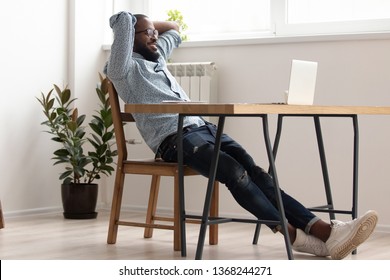 Relaxed african american business man chilling in office room finished job well done, black male employee take break rest at desk holding hands behind head feel no stress free relief in work space
