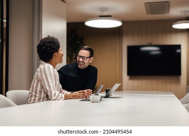 Relaxed african-american woman, enjoying the company of her interesting coworker. - Shutterstock ID 2104495454