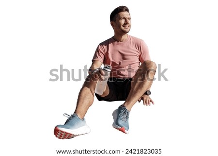 Relaxed athlete in a pink t-shirt taking a break with a water bottle, wearing a fitness tracker, casually seated, isolated on a white background.
