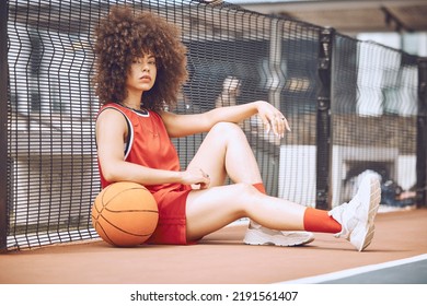 Relaxed, Attitude And Cool Female Basketball Player Relaxing Outdoors On A Court. Portrait Of A Trendy And Fashionable Black Woman Athlete Sitting On The Floor With A Ball After Training