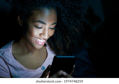 Relaxed black girl portrait using phone at night