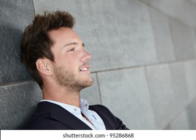 Relaxed Business Man Thinking With Head Leaning On Wall