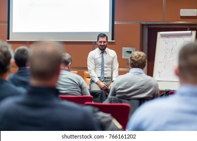 Relaxed Businessman Giving a Talk at Informal Business Meeting. Audience in the conference hall. Business and Entrepreneurship concept.