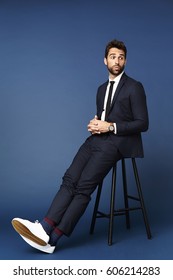 Relaxed Businessman Sitting On Stool In Studio