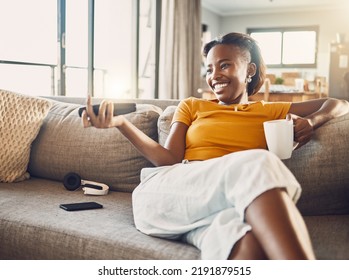 Relaxed, carefree and smiling young female watching tv and streaming movie at home on her living room sofa. Happy, casual and comfortable woman sitting on her couch and enjoying her leisure free - Shutterstock ID 2191879515