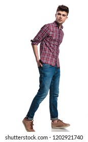 Relaxed Casual Man Wearing Jeans Walks On White Background With Hands In Back Pockets And Looks To Side, Full Body Picture