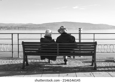 Relaxed Couple Of Elderly People Seen From Behind Admiring The View.Black And White Photos. Background Lake Maggiore.