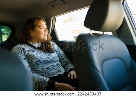 Relaxed fat young woman smiling while taking a trip on a taxi or ride share app car Stockfoto © 