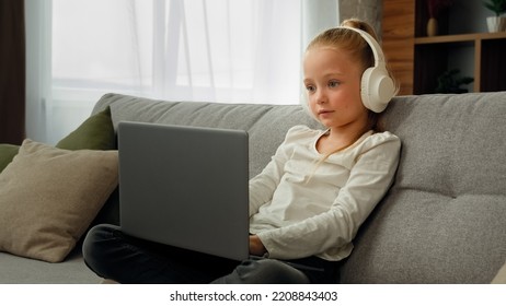 Relaxed Funny Pupil Girl Wearing Headphones Using Laptop Greeting Classmates In Video Conference Call Talking Online With Teacher Remotely Via Webcam Home Distant Education Due To Coronavirus Pandemic