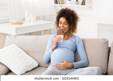 Relaxed Future Mom Eating Chocolate Bar, Resting On Sofa At Home, Copy Space