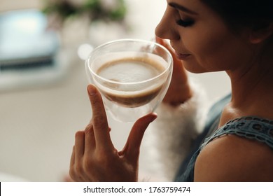 relaxed girl at home drinking coffee.Inner peace.The girl is sitting comfortably on the sofa and drinking coffee - Shutterstock ID 1763759474
