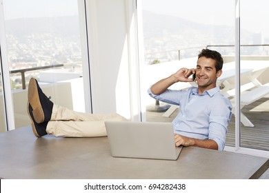 Relaxed guy takes a call from office at home