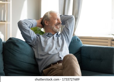 Relaxed happy grey haired mature old man enjoying free lazy weekend time on sofa. Tranquil calm peaceful smiling senior middle aged grandfather resting on couch alone, dreaming planning future. - Powered by Shutterstock