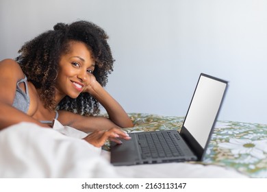 Relaxed Happy Woman Using Laptop In Her Bed At Home. Leisure Net Surfing And Media Consumption Concept.